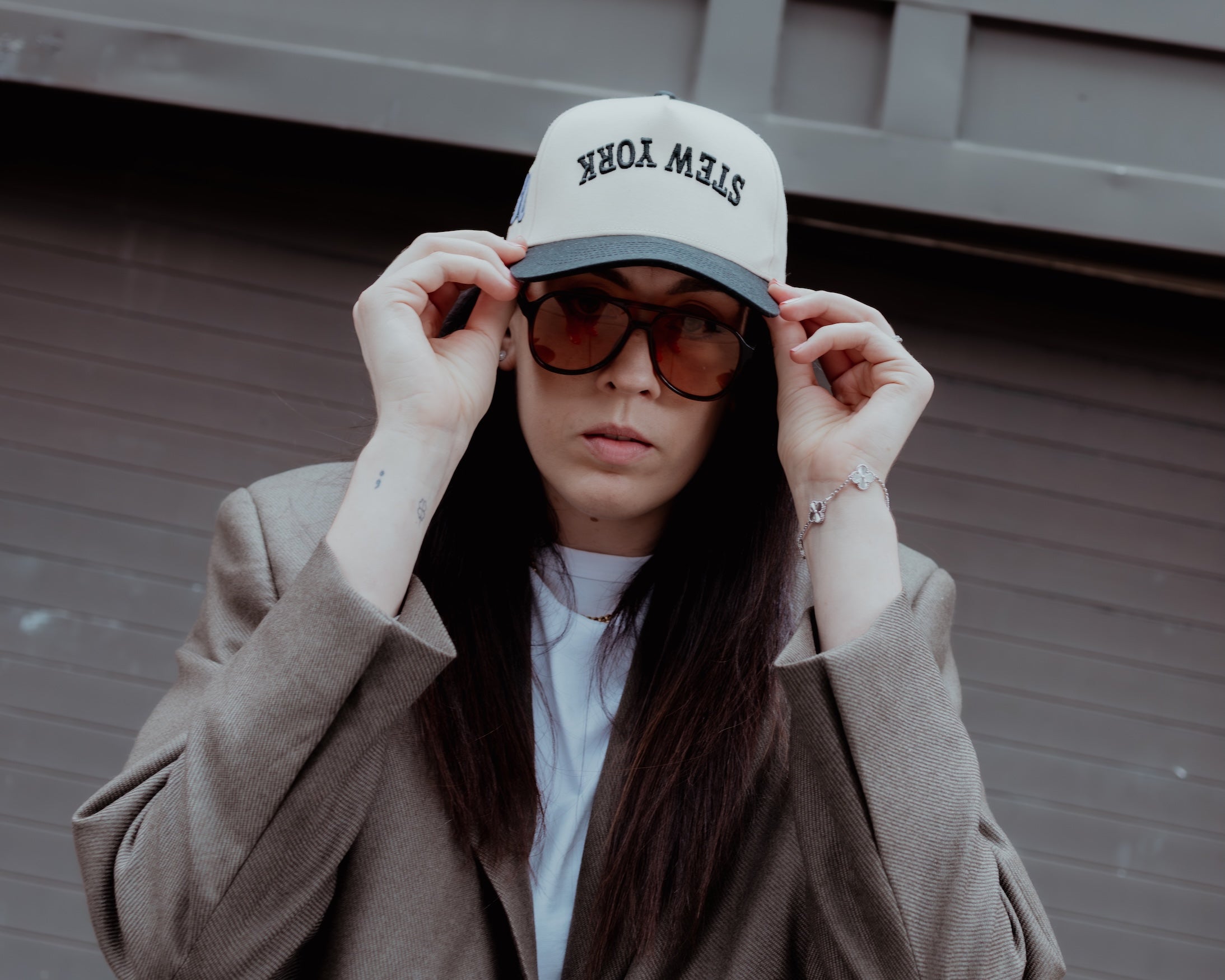 Person wearing a cap and sunglasses with a blurred background
