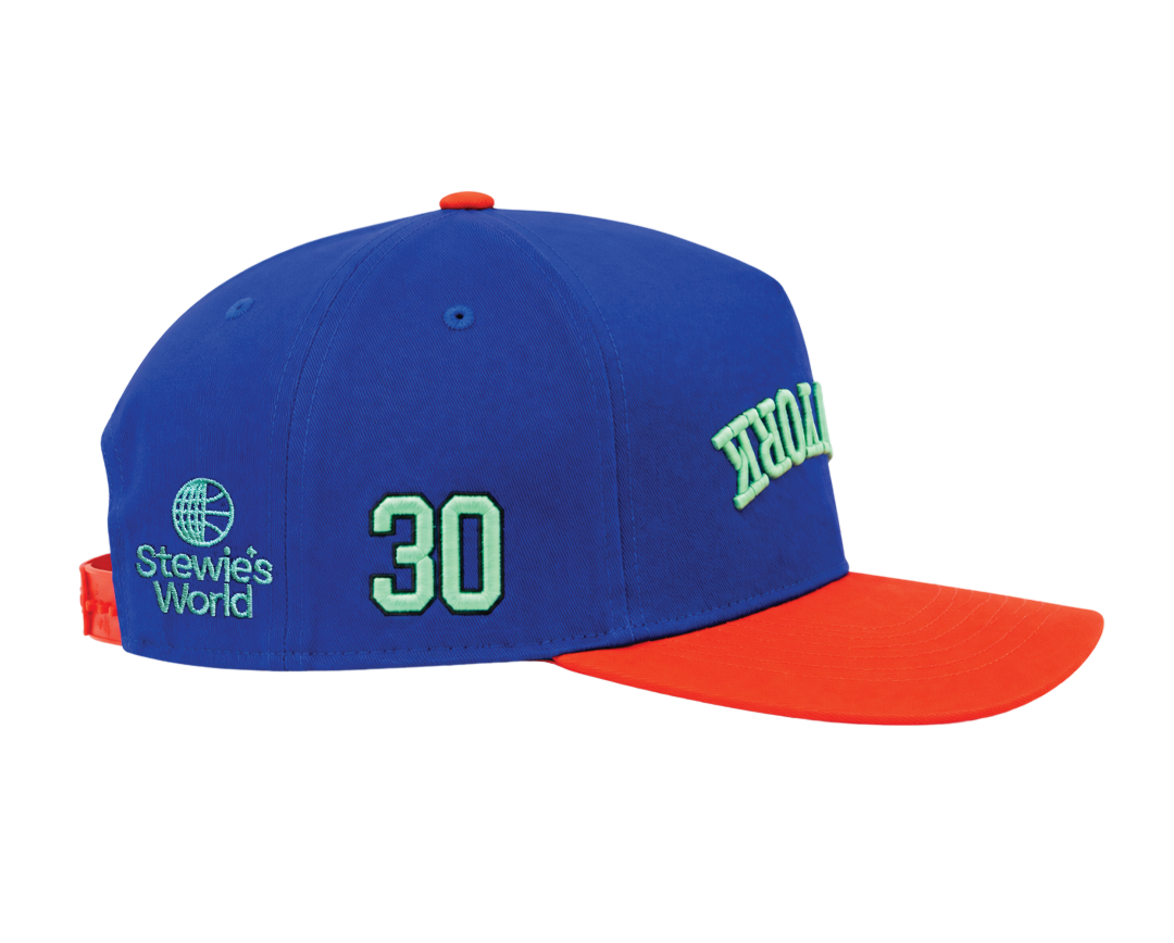 A blue baseball cap with a bright orange brim, featuring light green embroidered details including the number 30, 'Stewie's World' logo.